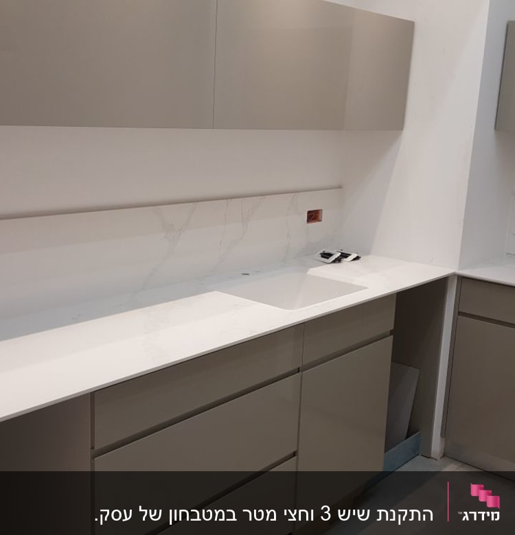 משטח שיש לבן עם כיור במטבח מודרני
